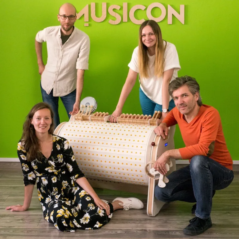 Ida Laszczuk i zespół Musicon z instrumentem przy zielonej ścianie